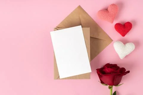 Kraft envelope with a blank sheet layout with a red rose and three hearts on  Foto stock