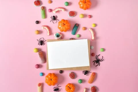 Kraft envelope with empty paper on the background of various sweets on a pink Stock Photos
