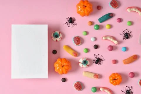 Kraft envelope with empty paper on the background of various sweets on a pink Stock Photos