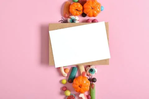 Kraft envelope with empty paper on the background of various sweets on a pink Stock Photos