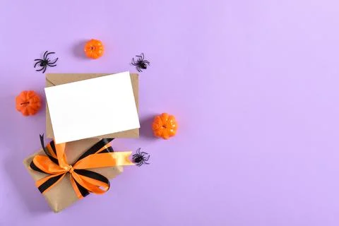 Kraft envelope, gift, pumpkins and spiders on a purple background. Happy hall Stock Photos