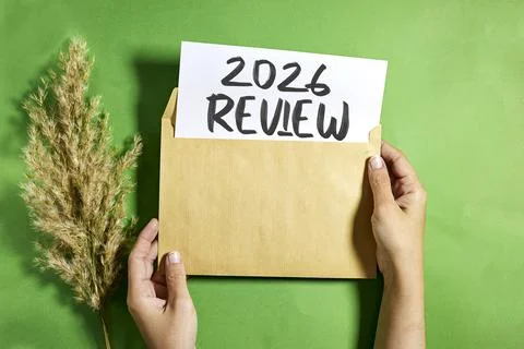 Kraft envelope is held by two hands, revealing a white card that reads '2026 REV Stock Photos