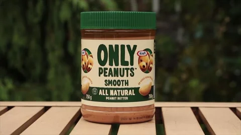 Kraft only peanuts smooth all natural peanut butter 750g outdoors on light brown Stock Footage 249424795