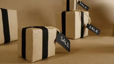 Kraft paper gift boxes displaying sale tags and black ribbons Stock Photos