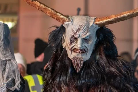 Krampus with an expressive mask walks in the column of the festival processio Stock Photos