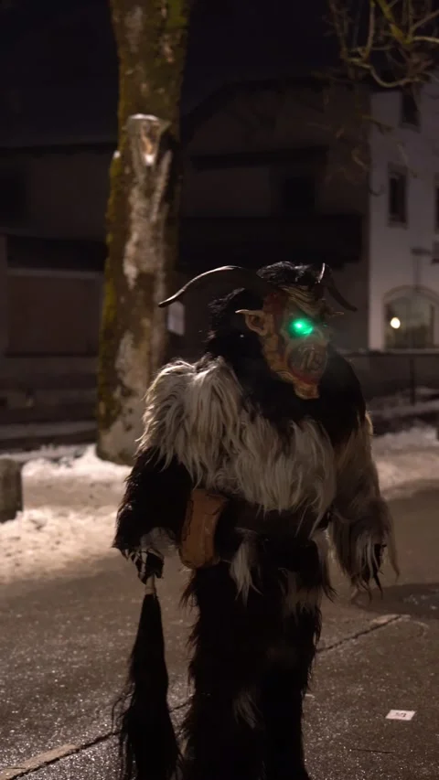 Krampus performers marching through a crowded street during Stock Footage 323585461