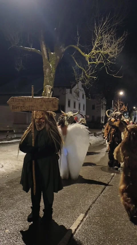 Krampus performers marching through a crowded street during Stock Footage 323585465
