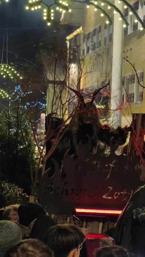 Krampus performers marching through a crowded street during Stock Footage 323585725