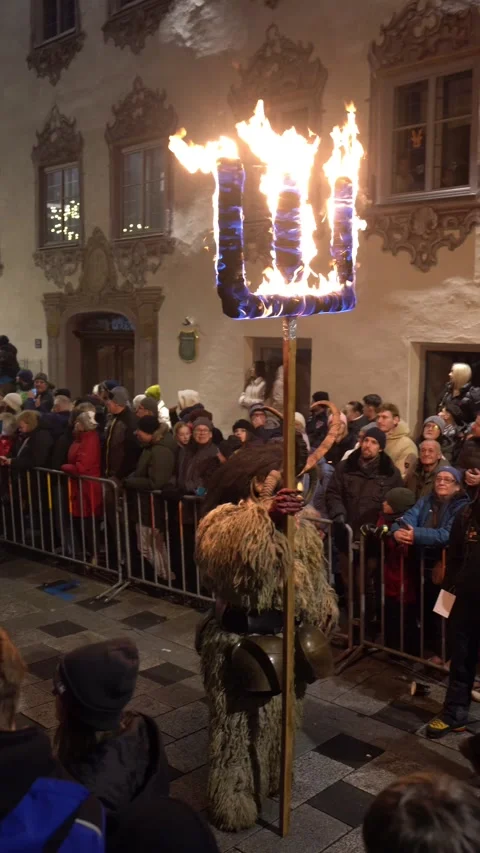 Krampus performers marching through a crowded street during Stock Footage 323585762