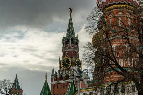 Kremlin Clock Tower and St. Basil Cathedral Domes Under Moody Skies in Cent.. Stock Photos