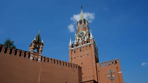 Kremlin wall, Clock on Spasskaya Tower of the Kremlin against the blue sky on a Stock Footage 110168955