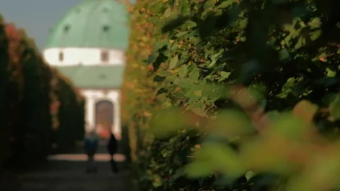 Kromeriz -  Path lined by tall hedge with defocused people and rotunda Stock Footage 120757484