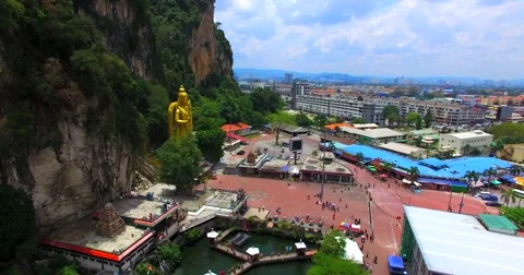 Kuala Lumpur and Batu Caves with the Murugan statue. Aerial Stock Footage