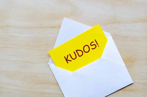 KUDOS text on yellow notepad inside an envelope. Achievement concept KUDOS... 스톡 사진
