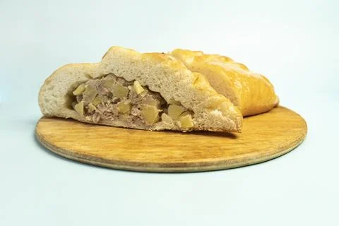 Kulebyak or khachapuri. triangular pie with filling on a blue table. Traditio 写真素材
