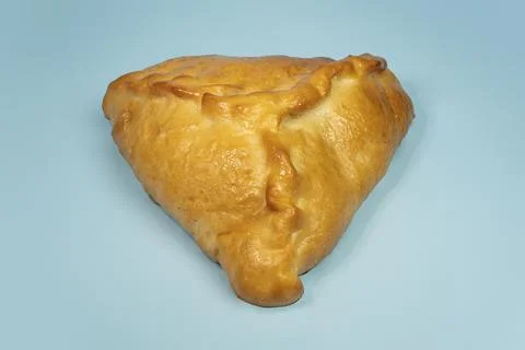 Kulebyak or khachapuri. triangular pie with filling on a blue table. Traditio 스톡 사진
