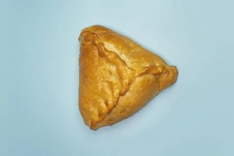 Kulebyak or khachapuri. triangular pie with filling on a blue table. Tradit.. 스톡 사진