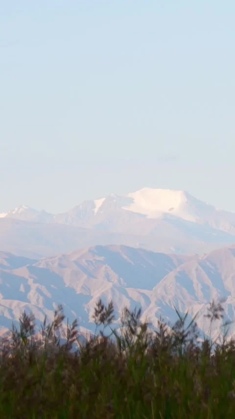Kungey Ala Too mountains over Issyk Kul Lake, Kyrgyzstan. Snow-capped peaks.. Vídeos de archivo 335884445