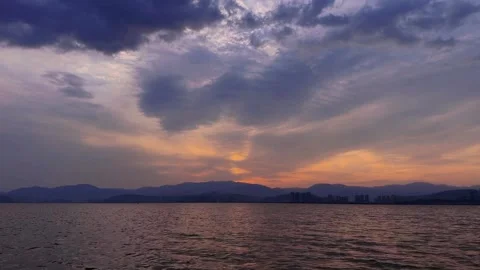 Kunming Dian Lake twilight after sunset with city skyline and mountain refle 库存影片 333552882