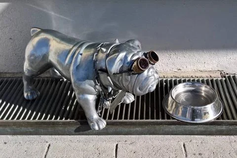  Kunst oder Kitsch: Festgeketteter Hund mit Sonnenbrille vor einem Napf bz... Stock Photos