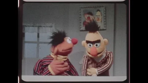 Kuwait 1970s: Ernie the Muppet puts down banana peel in front of Muppet Bert and Stock Footage 324571797