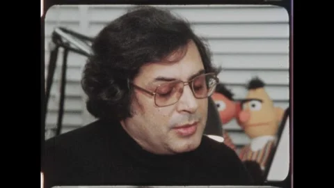 Kuwait 1970s: Man is interviewed seated with Bert and Ernie puppet in Stock Footage 324571883