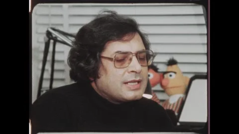 Kuwait 1970s: Man is interviewed seated with Bert and Ernie puppet in Stock Footage 324571902