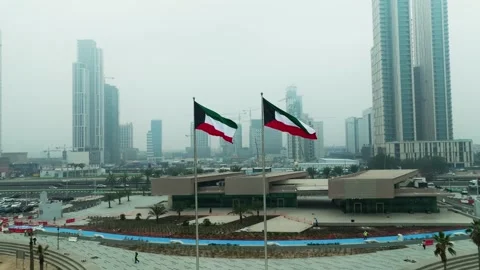 Kuwait flag waving in the sky with Kuwait buildings in the background Stock Footage 266980003