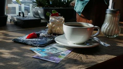 Kuwaiti banknotes lying under a cup of coffee Stock Photos