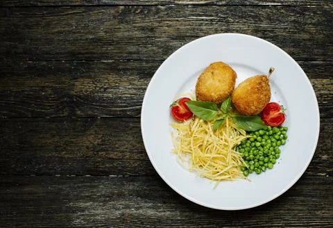 Kyev cutlets with bone, green beans and noodles Stock Photos
