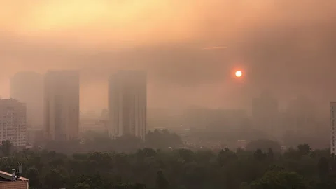 Kyiv sunrise timelapse with sun through smoke from drone strike fires July .. Stock Footage 312463752