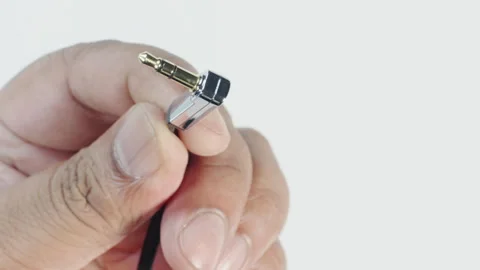 L-Shaped Auxillary Headphone Jack In Hand Stock Footage 248775524