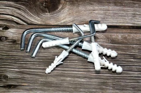L-shaped screw hooks with plastic wall anchors, versatile fasteners for han.. Foto stock