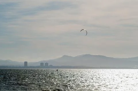LA MANGA, SPAIN - MARCH 4, 2019 Kiteboarder enjoys surfing in blue water in t Stock Photos