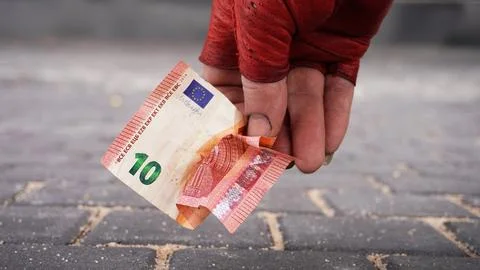 La mano de Tramp con un guante rojo levanta un billete de diez euros Stock Photos
