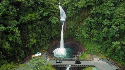 La Paz waterfall dropping beside bridge surrounded by rainforest and visiting Stock Footage 344915176