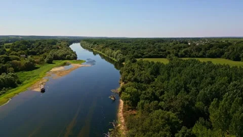 La Vienne river winds through lush countryside near Chinon under blue sky Stock Footage 317537775