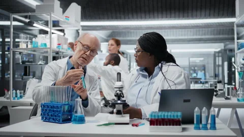 Lab analytical chemists working together, investigating liquid polymer Stock Footage 325918703