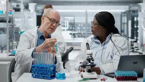 Lab analytical chemists working together, investigating liquid polymer Stock Footage 327336490