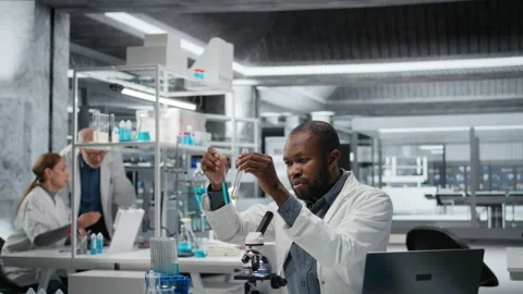 Lab assay development specialist investigating blue liquid polymer Stock Footage 326368107