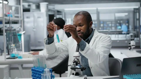 Lab assay development specialist investigating blue liquid polymer Stock Footage 327099717
