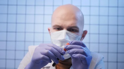 Lab assistant in gloves and mask holds coronavirus sample Stock Footage 124616374