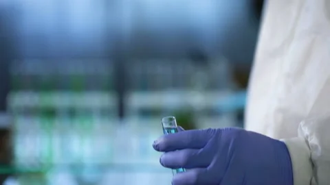 Lab assistant holding test tube, comparing information about research in tablet Stock Footage 88343481