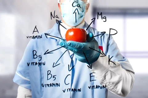 Lab assistant holding a tomato vegetable. Stock Photos