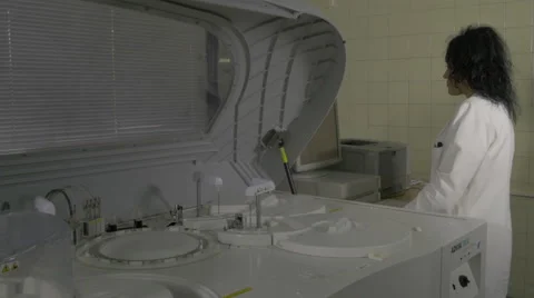 Lab assistant loading data on computer,clinical laboratory device, blood testing Stock Footage 58951816