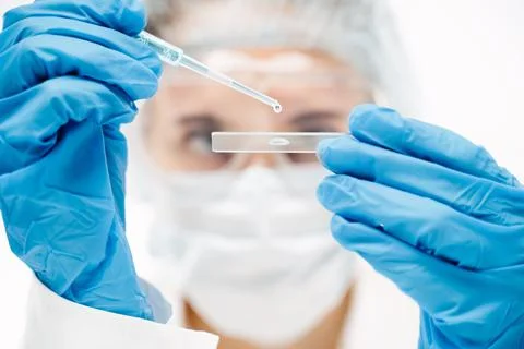 Lab assistant making coronavirus test with blue reagent in modern clinic Foto stock