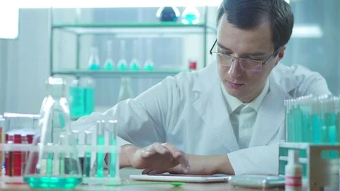 The lab assistant is working behind the laboratory tablet Stockbeeldmateriaal 83211126