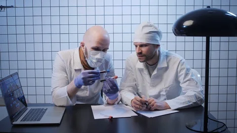 Lab assistants work samples of coronavirus in tubes at table Stock Footage 125930328