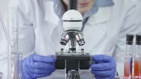 A lab with blue gloves technician is slowly turning the knobs on a 動画素材 138907643