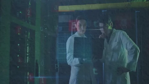 Lab-coated techs holding laptop, starting security scan while server racks Stock Footage 333444772